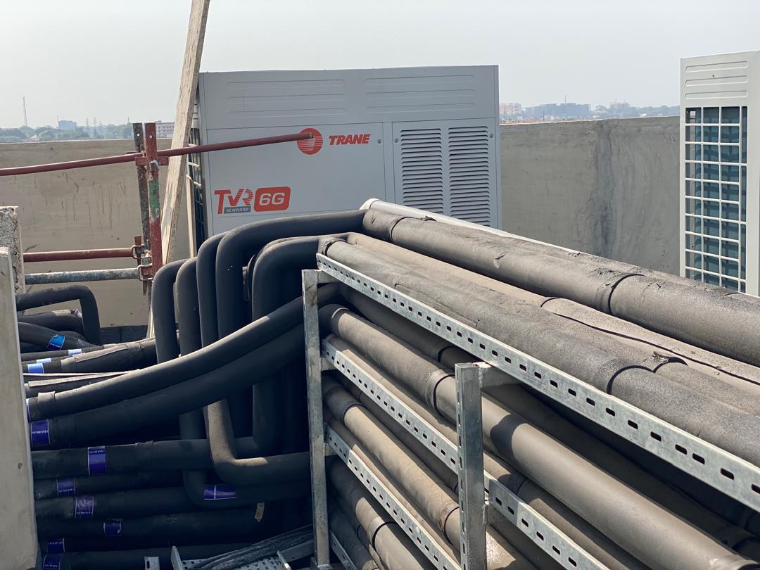 Rows of rooftop HVAC units with insulated piping