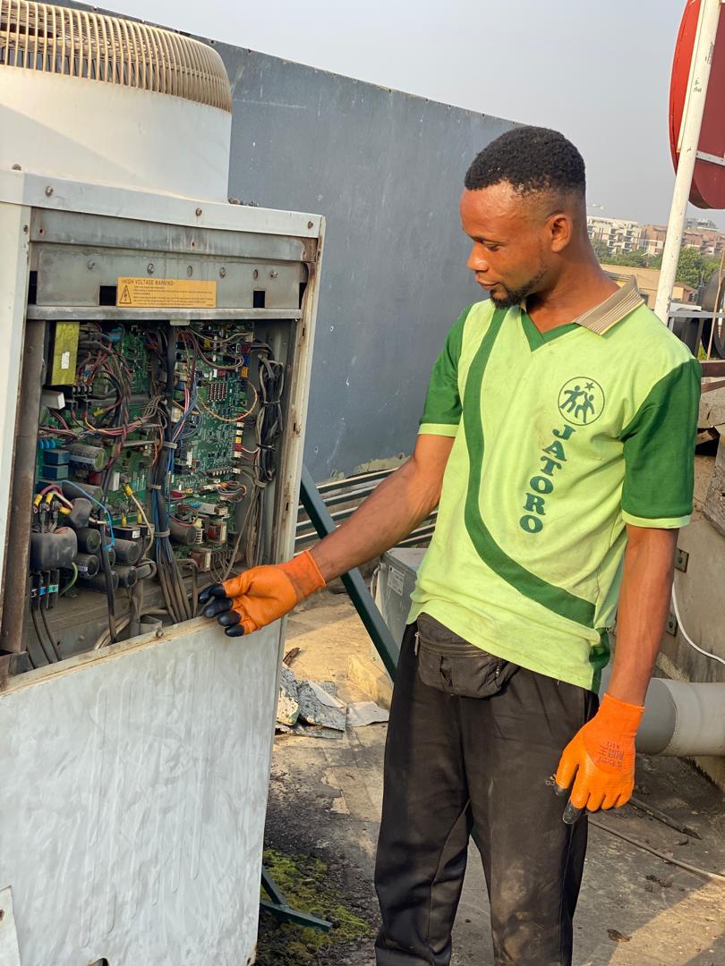 Technician troubleshooting a commercial HVAC unit